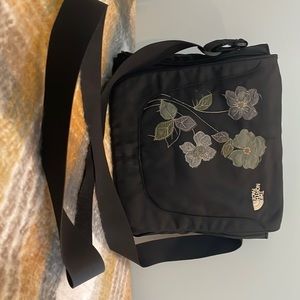 Black with flower accent, nylon, adjustable strap, good condition.